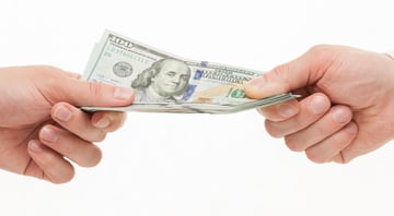 Businesspeople's hands holding dollars Cash Advance Apps | Source: The College Investor