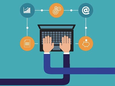 This illustrative image for "The College Investor" article on Capital One 360 banking features a central laptop with hands poised over the keyboard, representing online financial management. Surrounding the laptop are various circular icons connected by lines, symbolizing different aspects of digital banking. To the top left, a blue circle contains a white bar graph with an upward trend, indicating financial growth or investment performance. A yellow gear icon to the top center suggests the mechanics or processes involved in managing accounts. To the top right, a blue "@" symbol within a circle signifies online communication or digital presence. Below the laptop, a yellow document icon on the left denotes paperwork or statements, while a piggy bank icon on the right represents savings and money market accounts. The overall graphic highlights the comprehensive online banking services discussed in the Capital One review.