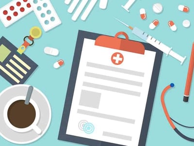 This image displays a collection of medical and insurance-related items scattered across a light blue background, visually representing the various aspects of college student health insurance options. Prominently featured are two white blister packs of pills, one with red pills and the other with white pills, symbolizing medication and health needs. A pair of white medical gloves is positioned towards the top, along with multiple loose white and red capsules and pills, and two syringes, one larger than the other, suggesting medical care and treatment. Towards the bottom right, a clipboard with a red clip holds a document featuring a red cross symbol, indicating medical records or health plan information. In the bottom left, an identification card with a key ring and an American flag design signifies identity and potentially insurance cards. The logo for "The College Investor" is visible in the bottom left corner, reinforcing the article's focus on inexpensive health insurance options for college and graduate students. The overall arrangement suggests the complexities and considerations involved in securing healthcare coverage while pursuing higher education.