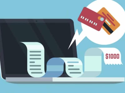 A digital illustration depicts a dark laptop screen with a long, light blue receipt or bill unfurling from it, representing online payments or transactions. To the right, a speech bubble contains two credit or debit cards—one red and one orange—suggesting alternative payment methods or the process of making payments. Another portion of the unfurling scroll shows "$1000" in red text, indicating the typical limits for money orders. The overall image, set against a teal background, visually connects to the article's discussion on money orders as a reliable payment method, highlighting their use for paying bills, the importance of guaranteed funds, and the transaction limits often associated with them, contrasting them with other options like prepaid debit cards or traditional checking accounts.