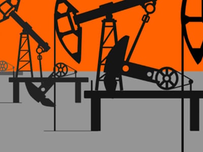 A graphic illustration depicts multiple black oil pumpjacks, also known as "nodding donkeys," silhouetted against a vibrant orange and gray background, transitioning from light gray at the bottom to dark gray, then to orange at the top. The pumpjacks are shown in various stages of their operational cycle, with their characteristic beam arms moving up and down, suggesting the continuous extraction of oil. The prominent text "THE COLLEGE INVESTOR" in white sans-serif font is positioned in the bottom left corner. This image visually represents the concept of investing in oil, a volatile commodity discussed in the accompanying article, highlighting the active and hands-on nature of oil investing compared to more passive strategies like index funds.