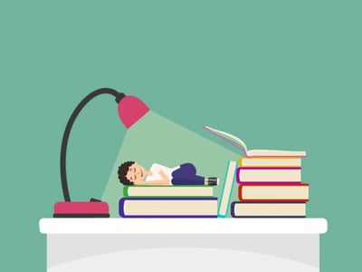 An illustration depicts a student, dressed in a white t-shirt and blue pants, peacefully sleeping on a stack of textbooks under the warm glow of a pink desk lamp. The student's face shows a serene expression, with eyes closed and a slight smile, suggesting exhaustion from studying. Beside them, another towering stack of books, one open as if recently read, emphasizes the academic rigor associated with graduate, professional, or medical school. The image, set against a teal background, visually represents the demanding nature of higher education and the potential need for financial aid, such as Grad PLUS loans, to support students through their extensive studies, as discussed in the accompanying article on financing an expensive education. The "The College Investor" logo is visible in the bottom left corner.