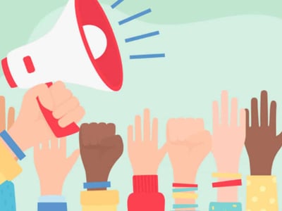 This image depicts a stylized illustration representing advocacy for student loan borrower protections, directly relating to the California Student Borrower Bill of Rights discussed in the article. A prominent red and white megaphone in the upper left corner, held by a light-skinned hand, points rightward, emitting three blue sound waves, symbolizing a powerful message or announcement. Below the megaphone, a diverse group of hands, some open and raised as if in agreement or participation, and others clenched into fists, are shown, suggesting unity and strength among student loan borrowers. These hands vary in skin tone, emphasizing broad support and the impact of the new law on a wide range of individuals. The background is a soft, light green. In the bottom left corner, the text "THE COLLEGE INVESTOR" is displayed in white, indicating the source of this important information regarding student loan reform and consumer protection laws like AB 376.