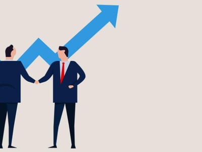 This image visually represents the concept of "Growth Investing: What Is It & How To Start," featuring two professional male figures shaking hands against a background with an upward-trending blue arrow graph. The man on the right is more visible, dressed in a grey suit jacket, white shirt, and a red tie, with dark blue pants, suggesting a business or financial context. The text overlay in prominent red letters reads "WHAT IS IT & HOW TO START," emphasizing the article's focus on defining growth investing and guiding beginners. The upward arrow symbolizes the appreciation and potential for outsized returns associated with growth stocks and funds, a key aspect of this aggressive investing strategy. The handshake signifies partnership, advice, or making a deal within the investment world.
