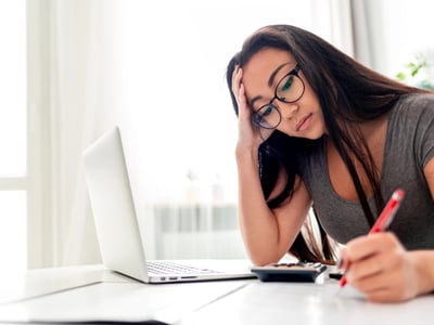 Frustrated woman figuring out financial aid and student loan caps. Photo: leszekglasner