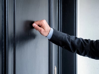 Close up of debt collector knocking on door. | Source: The College Investor