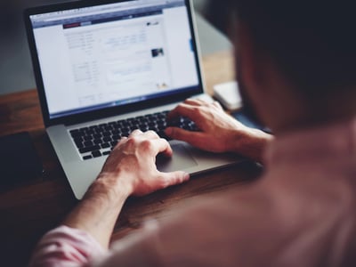 Cropped image of a college student working on a laptop. Source: The College Investor