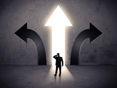 Silhouette of a businessman scratching his head while facing a large, glowing white arrow pointing upward, flanked by two dark arrows curving away. This visual metaphor represents the confusion federal student loan borrowers face as they transition from multiple legacy options like IBR, PAYE, and SAVE into the singular new path of the Repayment Assistance Plan (RAP).