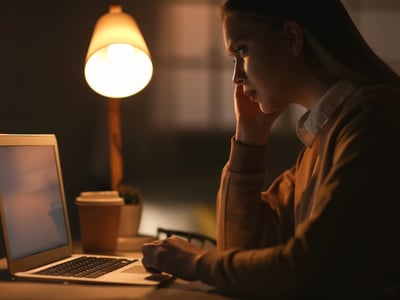 A young woman looking stressed at the computer reviewing her student loans. This image represents that 40% of Americans cannot likely qualify for private student loans. Source: The College Investor