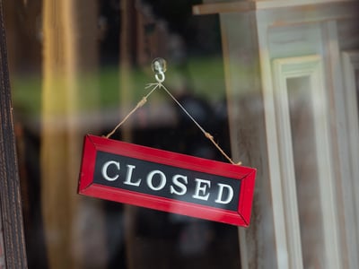 sorry we are closed sign hanging outside, representing colleges as risk of closure.
