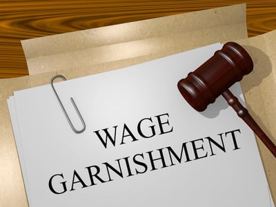 A folder and gavel with paperwork that says "Wage Garnishment". Source: The College Investor