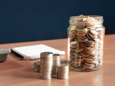 Coins stored in a jar, representing the interest earned on your savings account. Source: The College Investor