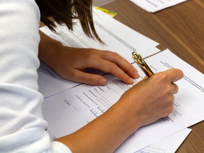 Close-up of a person filling out a college application.