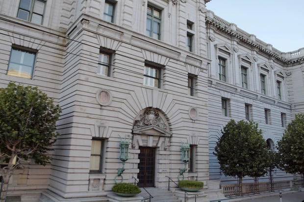 Exterior view of a grand, historic federal courthouse featuring classical stone architecture, rusticated walls, and an ornate arched entrance flanked by decorative green lantern fixtures. This stately building represents the Ninth Circuit Court of Appeals, the judicial battleground where the Education Department is currently arguing its motion to delay the Sweet v. McMahon borrower defense settlement&mdash;a critical legal decision that could impact up to $12 billion in debt relief for defrauded student loan borrowers. Source: The College Investor