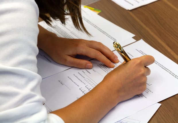 Close-up of a person filling out a college application.