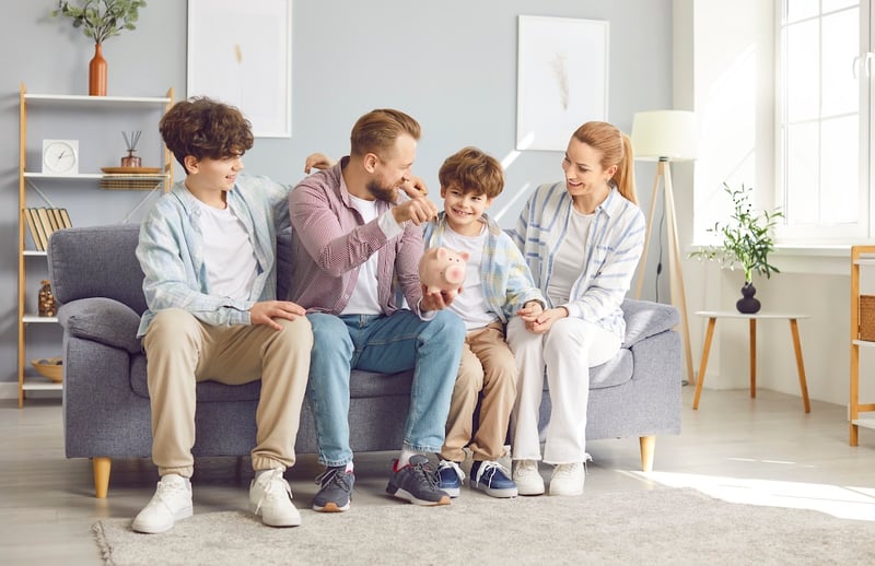 Positive Family With Children Putting Coin Into Piggy Bank Parents Saving For College And Retirement | Source: The College Investor