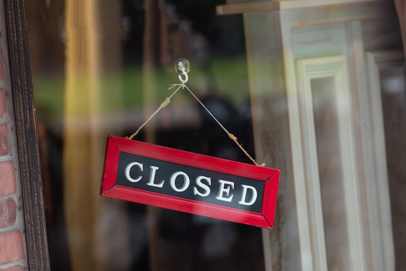 sorry we are closed sign hanging outside a restaurant, store, office or other sorry we are closed sign hanging outside, representing colleges as risk of closure.