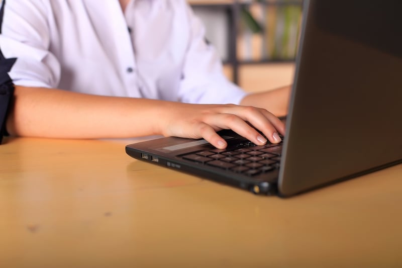 Students Rethink Majors A young girl sits at a computer deciding on college applications and majors in the face of AI.