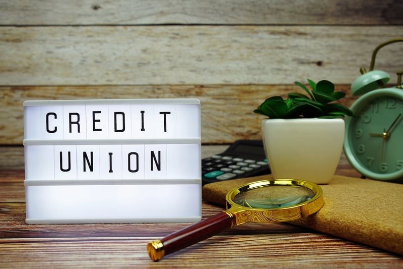 Credit Union CREDIT UNION letterboard text on LED Lightbox on wooden background. Source: The College Investor