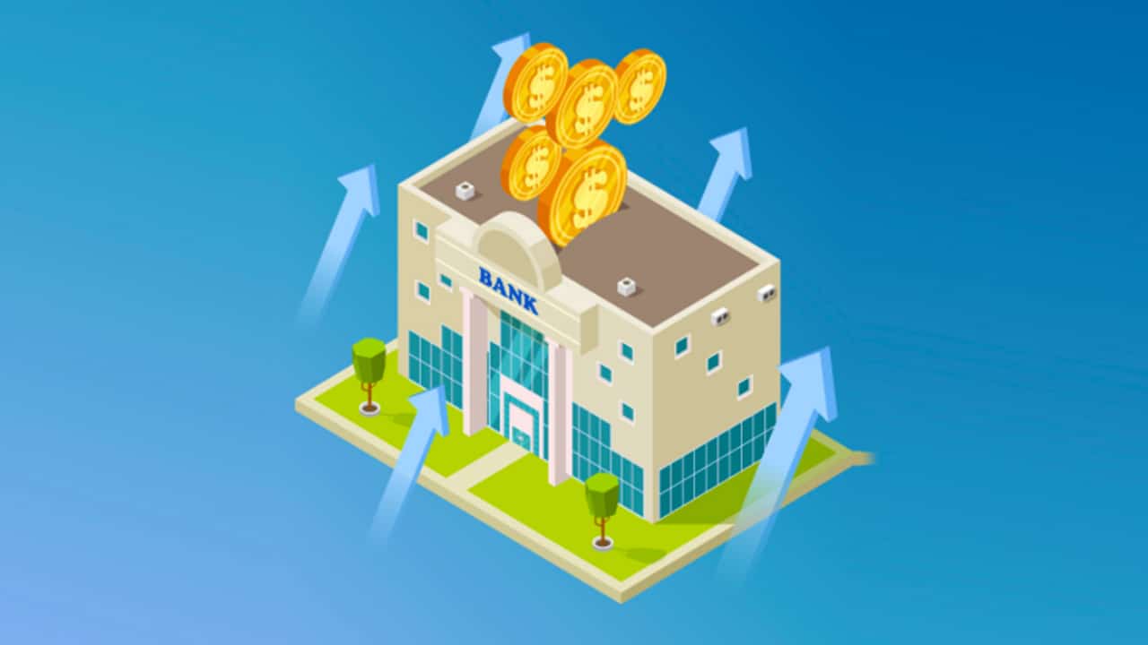 An isometric illustration on a blue background depicts a stylized, light brown bank building with "BANK" written above its entrance, featuring classical columns and large windows. Above the bank, several gold coins are stacked, with five coins visible, suggesting financial growth and high returns. Four light blue arrows emanate from around the bank's foundation and point upwards, further emphasizing the concept of increasing value or high yield, directly relating to the article's focus on high-interest checking accounts. The foreground prominently displays the text "THE COLLEGE INVESTOR," identifying the source of the financial advice. This image visually represents the core concept of a bank generating high interest on checking accounts, connecting directly to the article's discussion of the best high-yield checking account options available.