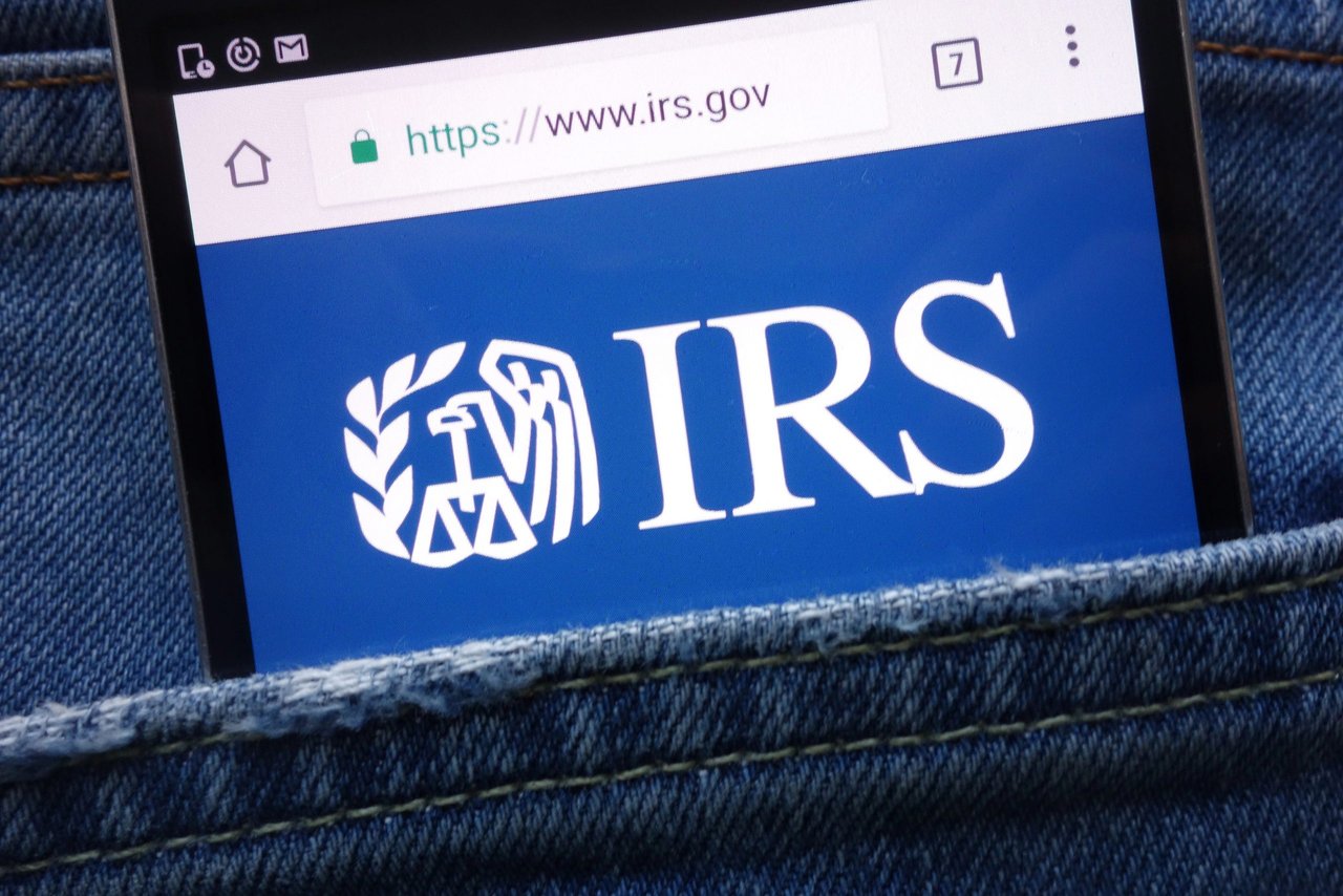 IRS (Internal Revenue Service) website displayed on smartphone hidden in jeans pocket 