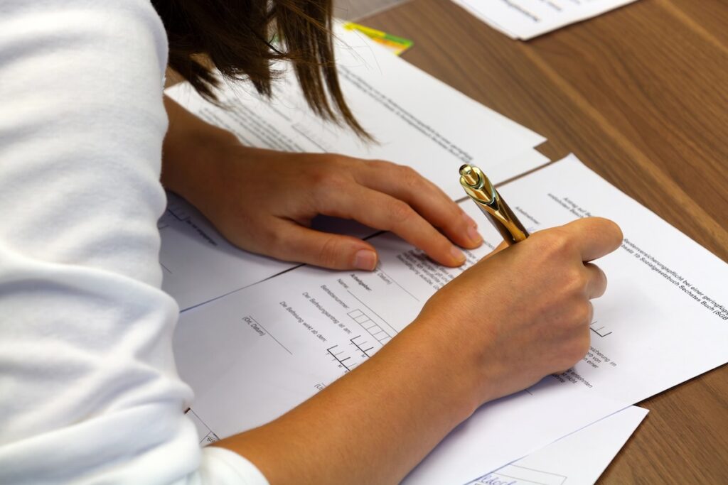 Close-up of a person filling out a college application.